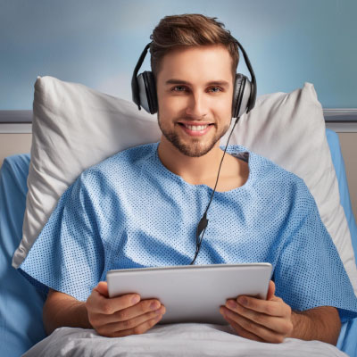 Guy in a hospital bed listening to Sheffield Hospital Radio on his laptop
