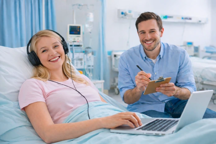 Patient listening to Sheffield Hospital Radio via a laptop with radio station song request collector sat beside her.